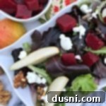 Overhead of Pickled Beet Salad with Pears, Walnuts & Goat Cheese on a white platter