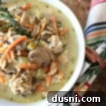 Chicken, Mushroom & Wild Rice Soup in a white bowl, ready to serve.