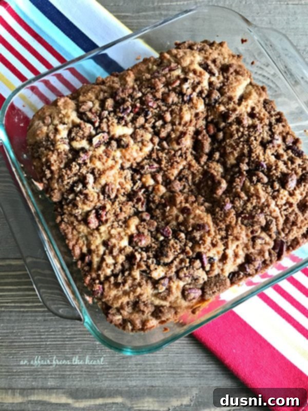 Golden Cinnamon Streusel Coffee Cake 4 Cinnamon Crunch Coffee Cake in an 8x8 pan, freshly baked and still warm, with visible pecan pieces in the topping.