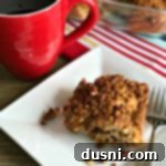 Golden Cinnamon Streusel Coffee Cake 8 Cinnamon Crunch Coffee Cake on a white plate with a cup of coffee on a table