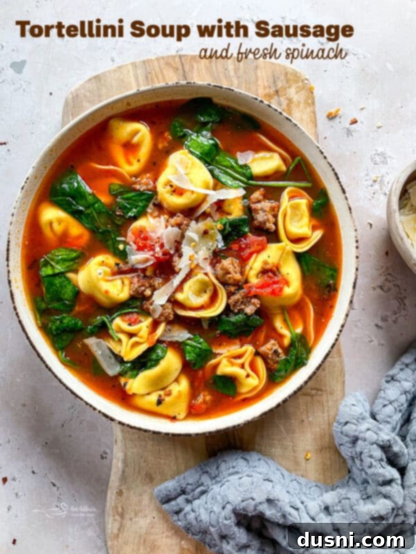 A beautiful close-up of a bowl of Tortellini Soup with Sausage and Spinach