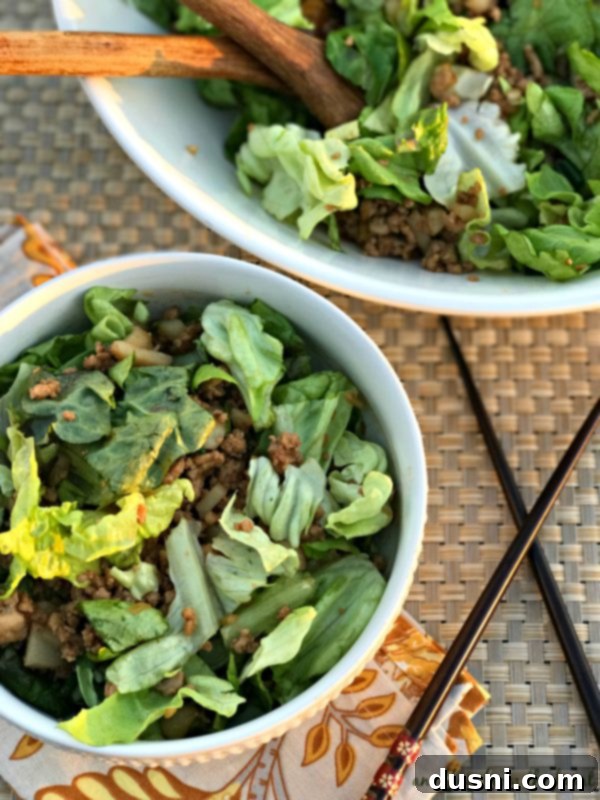 PF Changs Inspired Lettuce Wrap Salad 2 A large bowl of PF Chang's Copycat Lettuce Wrap Salad with fresh butter lettuce, ground chicken mixture, green onions, and water chestnuts, ready to be served.