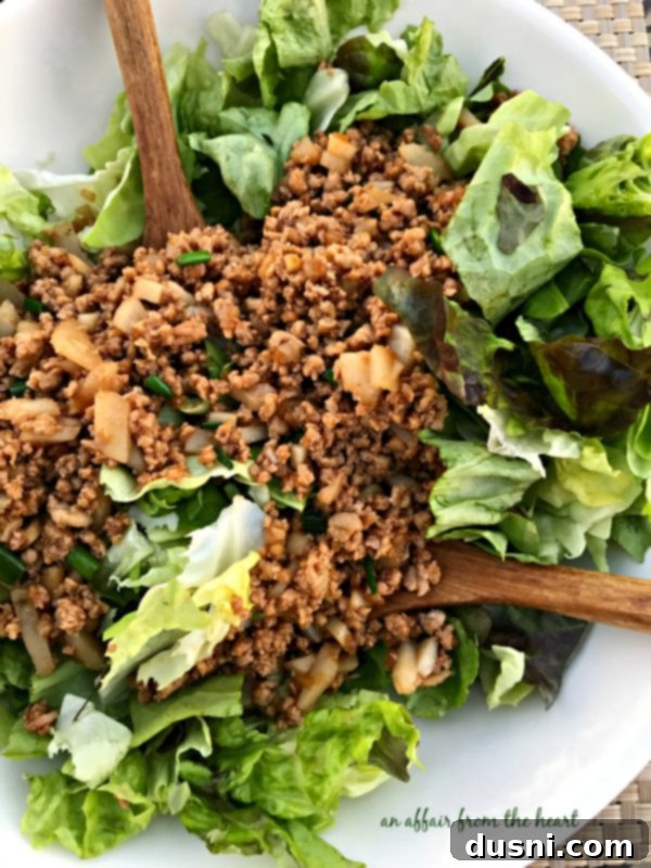 PF Changs Inspired Lettuce Wrap Salad 6 A serving of PF Chang's Lettuce Wrap Salad in a white bowl, showcasing the vibrant colors and fresh ingredients.