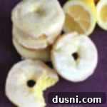 Close up of Baked Glazed Lemon Donuts and one with a bite out of it