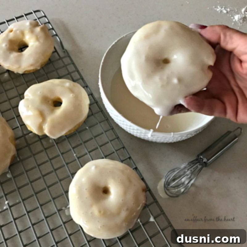 Freshly baked lemon donuts on a cooling rack after glazing