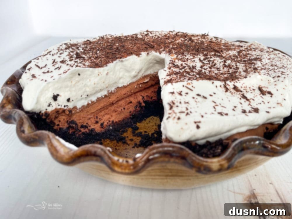A perfectly baked French Silk Pie, whole and untouched, sitting on a pie plate ready to be sliced.