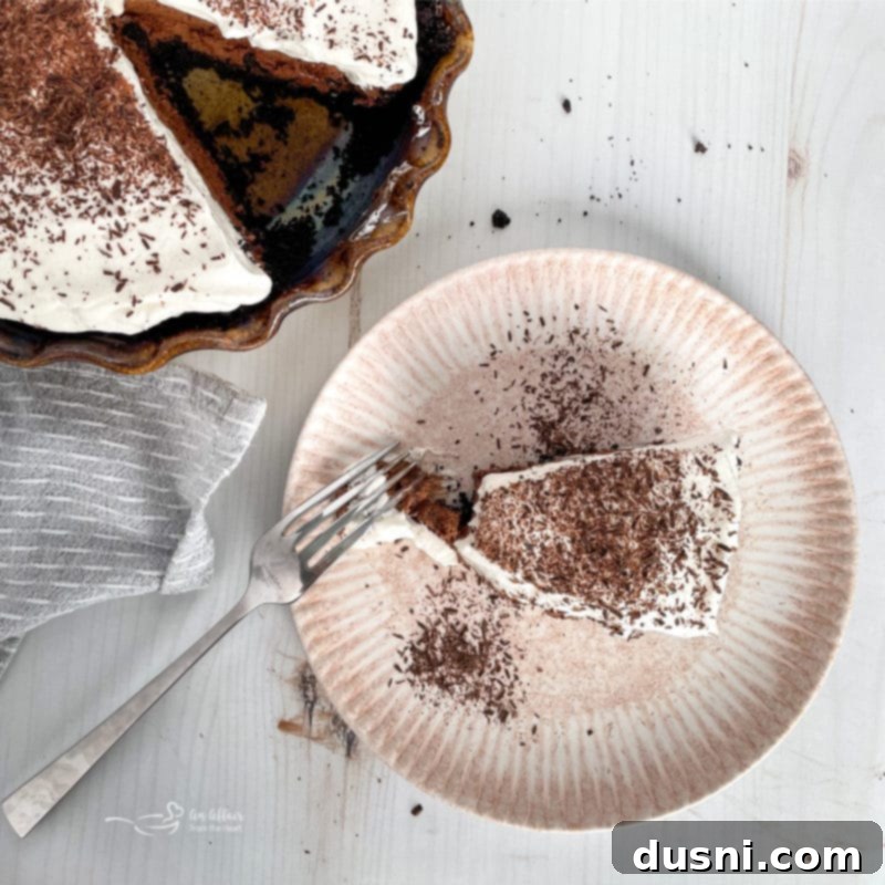 A pristine slice of French Silk Pie on a white plate, highlighting its smooth layers and rich appearance.