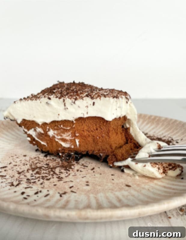 A single, perfectly cut slice of French Silk Pie presented on a minimalist white plate.