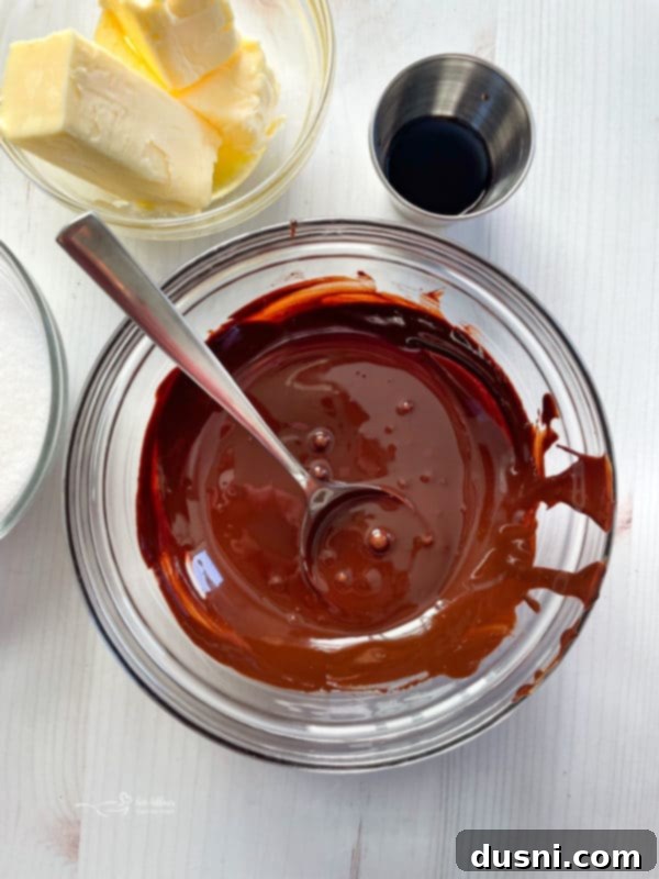 Melted unsweetened chocolate in a bowl with a spoon, ready to be incorporated into the filling.