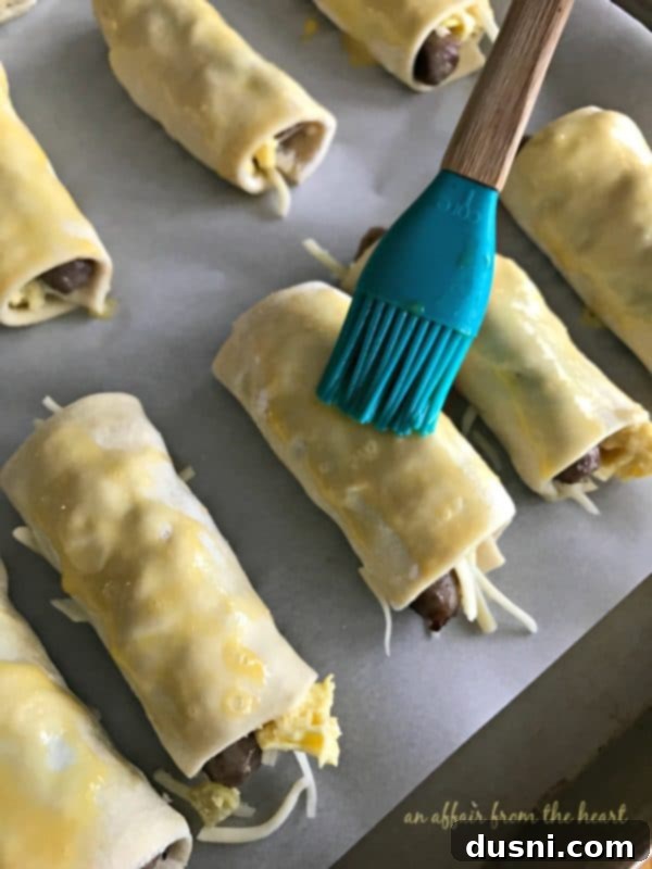 Prepared roll-ups on a baking sheet before baking