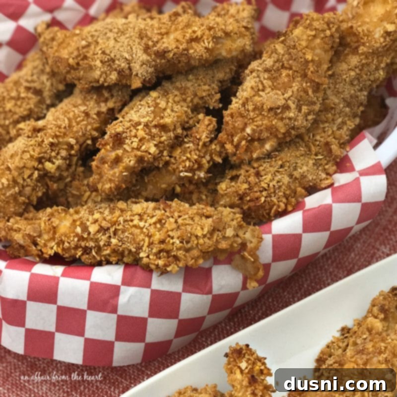 Zesty Oven-Baked Chicken Strips 2 Spicy Baked Chicken Tenders, golden brown and crispy, served in a basket with dipping sauce.