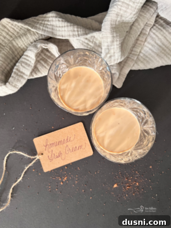 Velvet Homemade Irish Cream 7 A glass of homemade Irish cream served over ice, garnished with coffee beans.