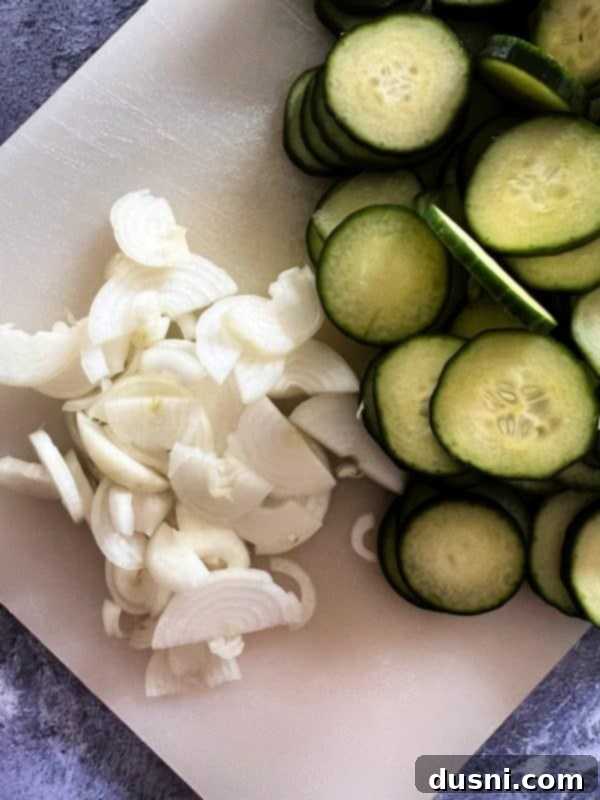 Jars of Sweet and Spicy Refrigerator Pickles with sliced cucumbers and onions
