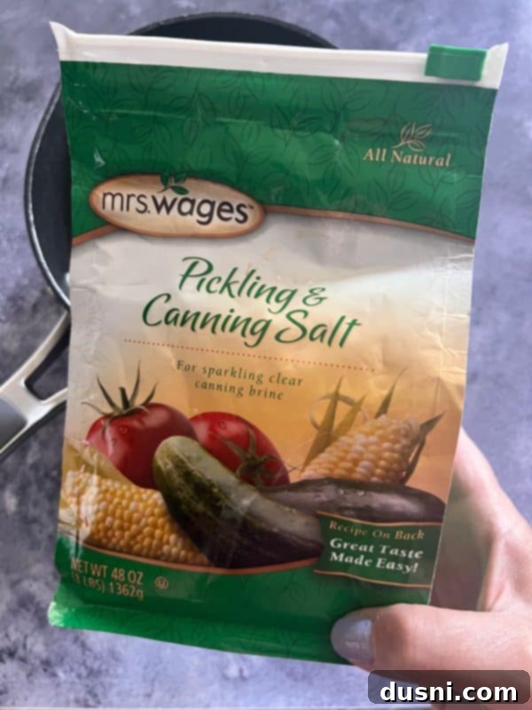 Jars of Sweet and Spicy Refrigerator Pickles on a wooden surface