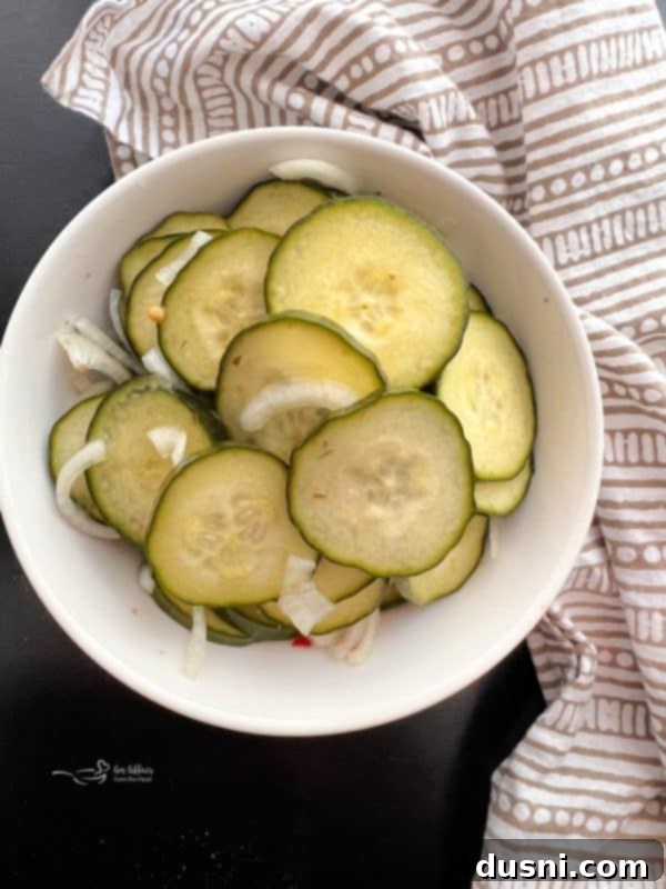 A jar of sweet and spicy refrigerator pickles viewed from above, showcasing the ingredients