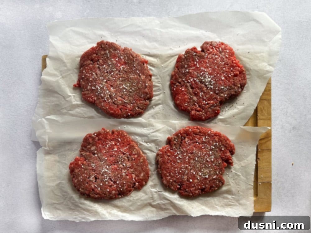 Signature Mushroom Swiss Burger 8 Step 3: Seasoning raw burger patties with salt and pepper.
