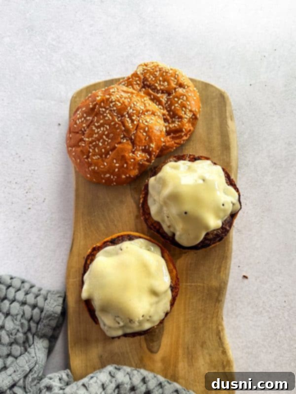 Signature Mushroom Swiss Burger 10 Step 5: Melted Swiss cheese and sautéed mushrooms on burger patties.