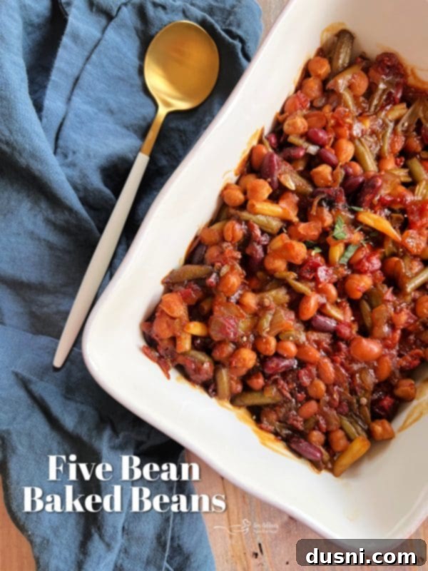 Hearty Five-Bean Bake 10 Five Bean Baked Beans in a white casserole dish with fresh parsley