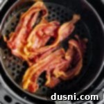 Perfectly Crispy Air Fryer Bacon 14 Freshly cooked air fryer bacon in the air fryer basket