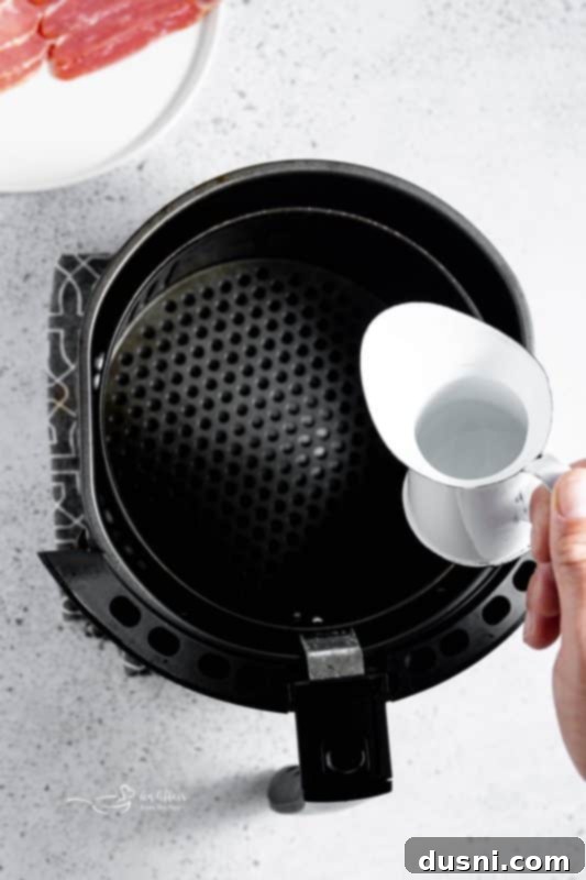 Perfectly Crispy Air Fryer Bacon 7 Air Fryer Bacon step 1: Adding water to the air fryer