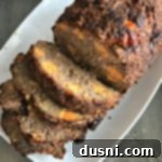 Moms Hearty Pork Sausage Meatloaf 10 Overhead view of Pork Sausage Meatloaf sliced on a white serving platter