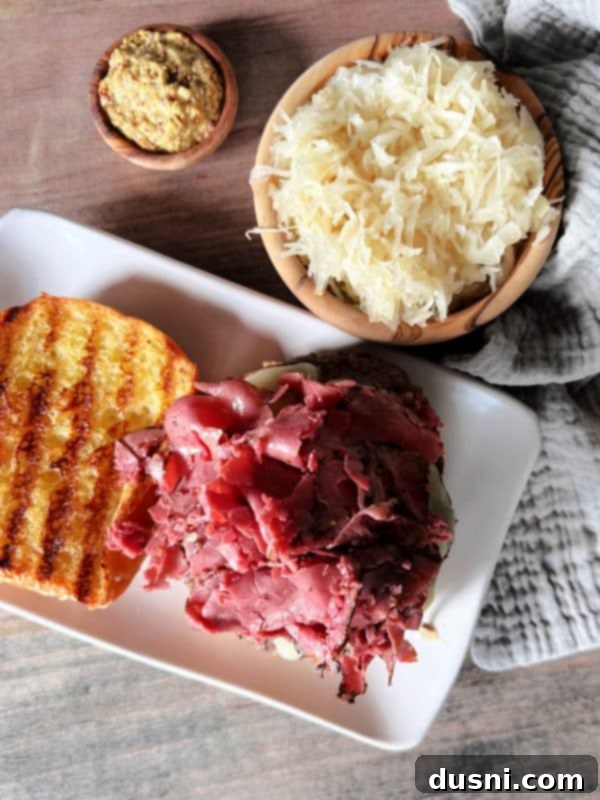 Adding burger patty and pastrami