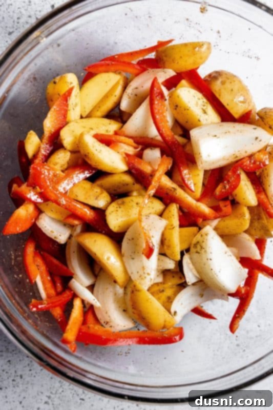 Potatoes, onion, and bell peppers coated in olive oil and spices