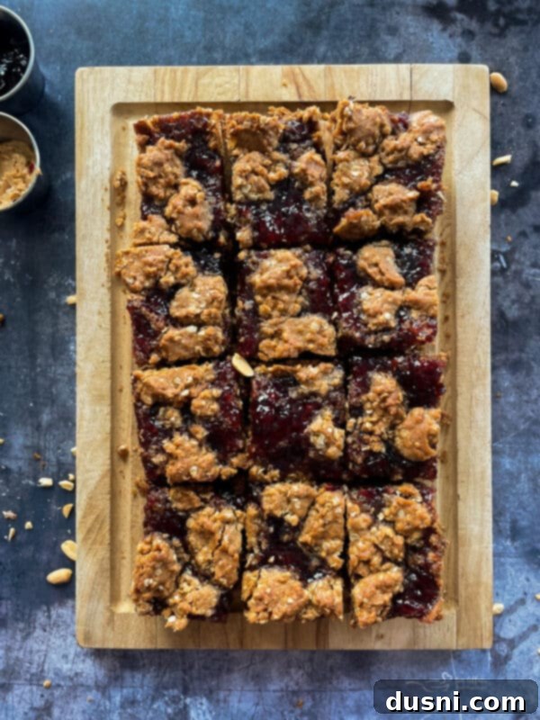 PB&J Oatmeal Cookie Bars on a white plate with a fork, showing the jelly swirl