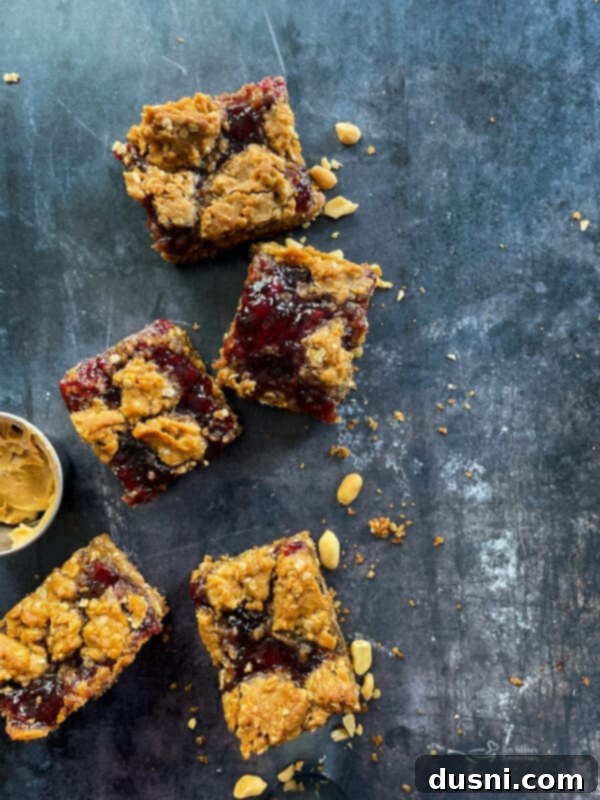 A stack of three PB&J Oatmeal Cookie Bars, showing the layers