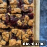 PB&J Oatmeal Cookie Bars cut into squares on a wooden board