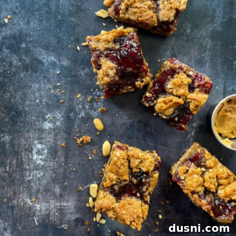 A wooden board filled with freshly baked PB&J Oatmeal Cookie Bars