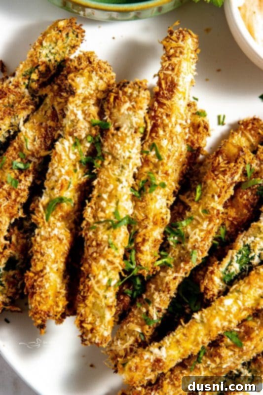 Crispy Air Fryer Zucchini Fries 3 Air Fryer Zucchini Fries served on a board with parmesan cheese