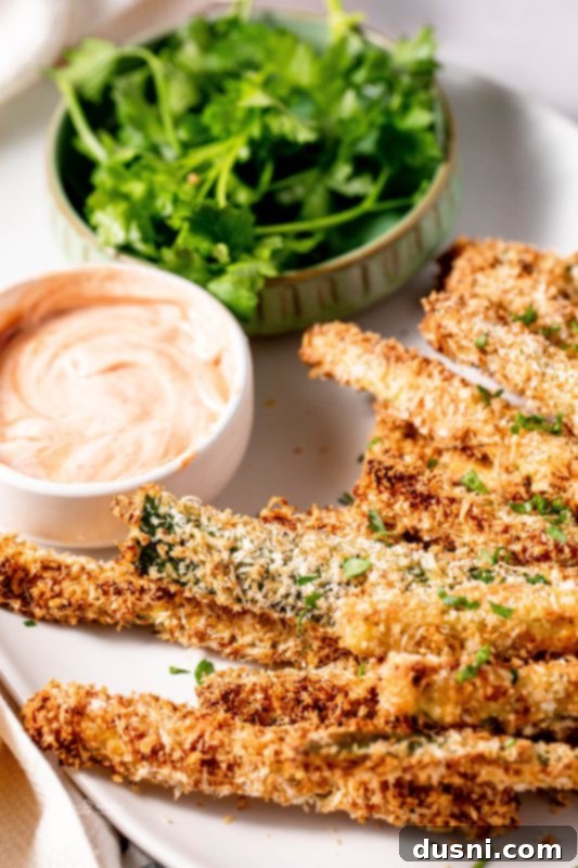 Crispy Air Fryer Zucchini Fries 5 Zucchini fries on a baking sheet, ready for the oven