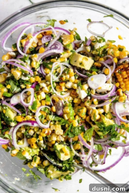 Step 5: Adding crumbled feta and pepitas to the salad mixture