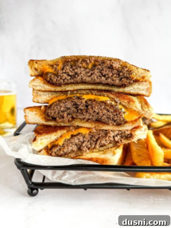 A Dunker Burger being assembled: a cheese-covered patty placed on toasted Texas Toast, with another slice of toast ready to be placed on top.