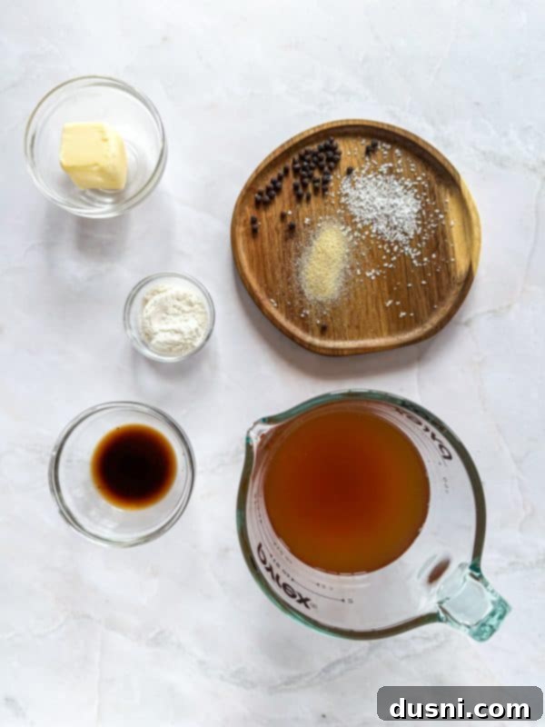 A close-up of a Dunker Burger being dipped into a small bowl of homemade au jus. The golden Texas Toast and melted cheese are visible.