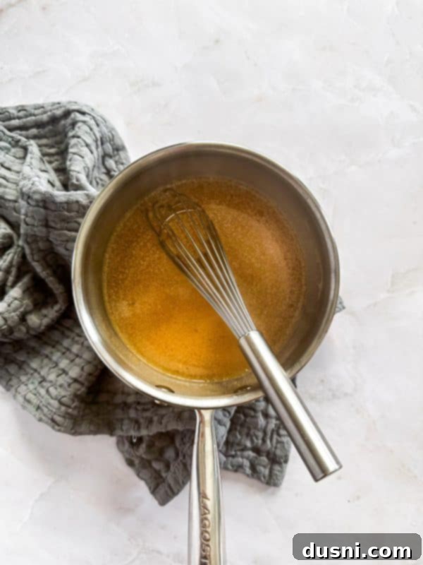 Step-by-step image of making au jus: melting butter in a saucepan.