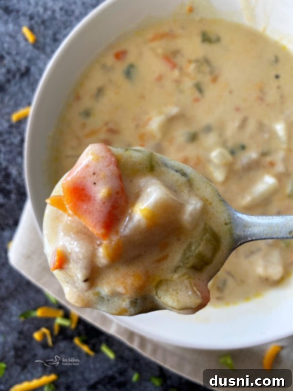 Top view of cheesy potato soup over white bowl