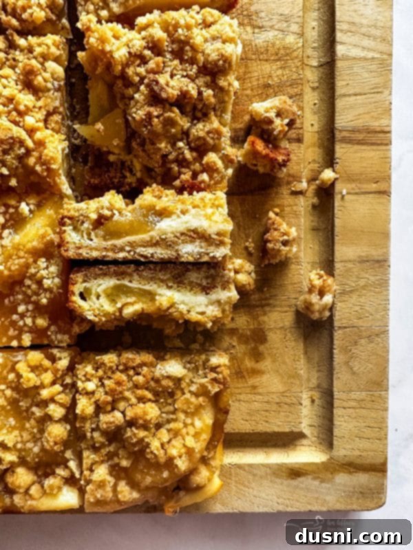 Close up of Apple Pie Crumb Bars with a golden crumb topping and visible filling layers