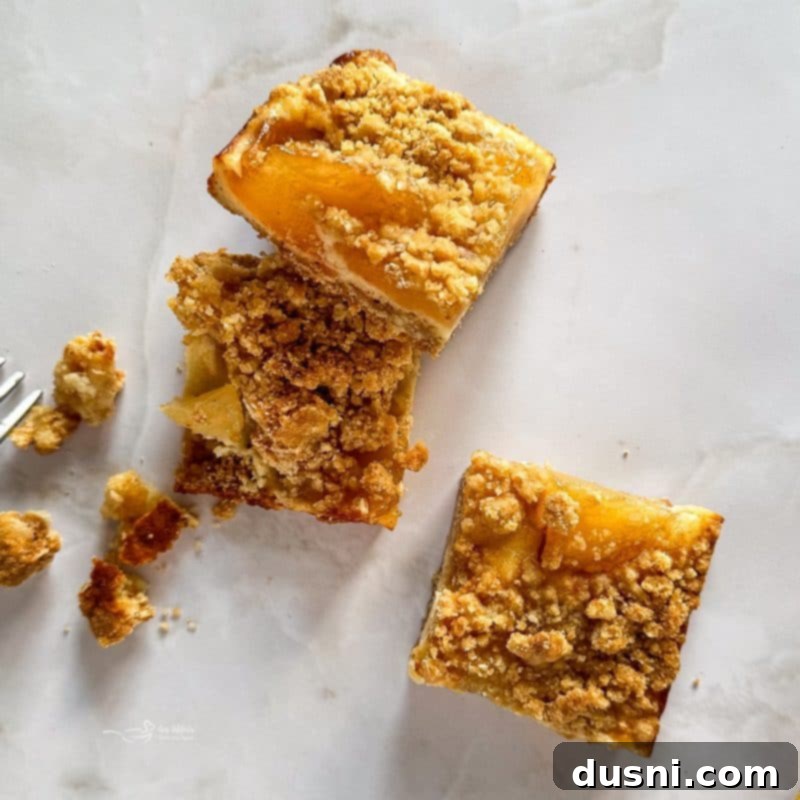 Several Apple Pie Crumb Bars served on a wooden board, with a rustic autumnal background