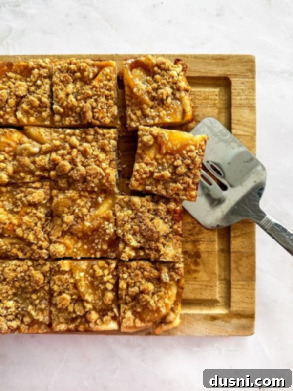 A large spoon scooping the apple pie filling onto the crust