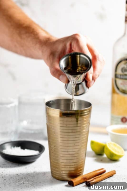 Apple Cider Margarita 8 A cocktail shaker filled with ice cubes.