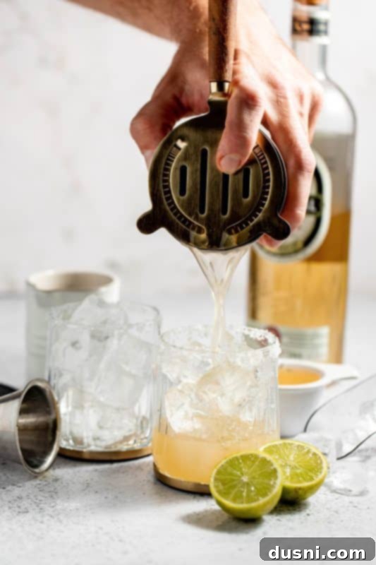 Apple Cider Margarita 10 A cocktail shaker being shaken to mix the ingredients.