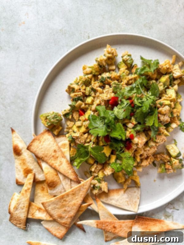 Irresistible Avocado Chicken Salad Dip 15 A bowl of avocado chicken salad dip with a rustic background.