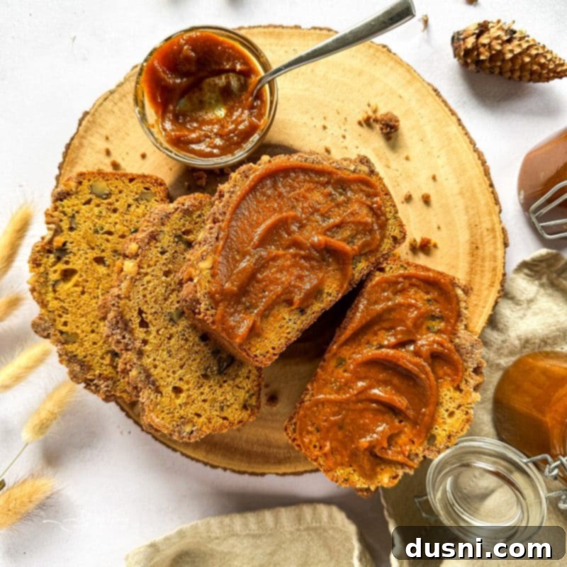 Pumpkin butter generously spread on a slice of homemade Pumpkin Zucchini Streusel Bread.