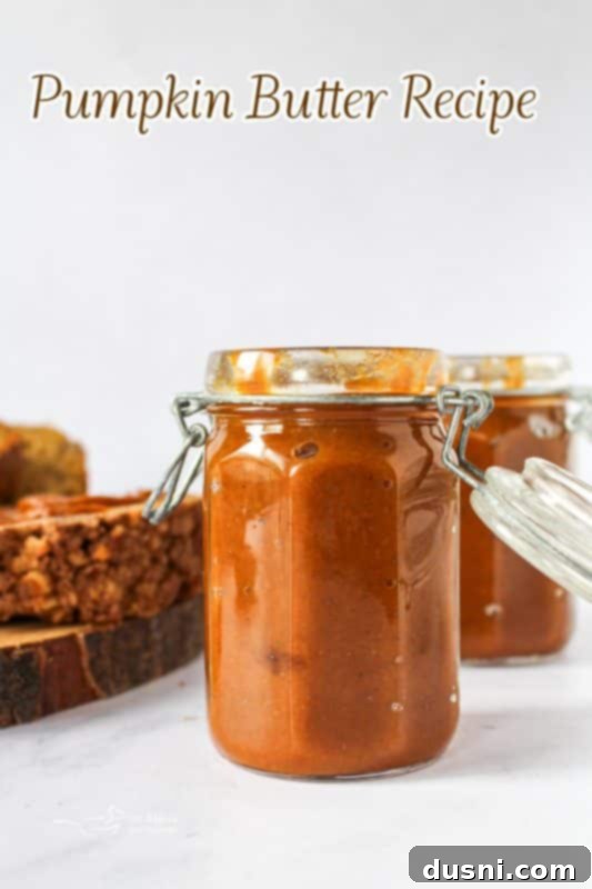 Hero shot of homemade pumpkin butter in a mason jar with a spoon, highlighting its autumn appeal.