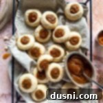 Snickerdoodle thumbprint Cookies and a small bowl of apple butter on a cloth lined tray.