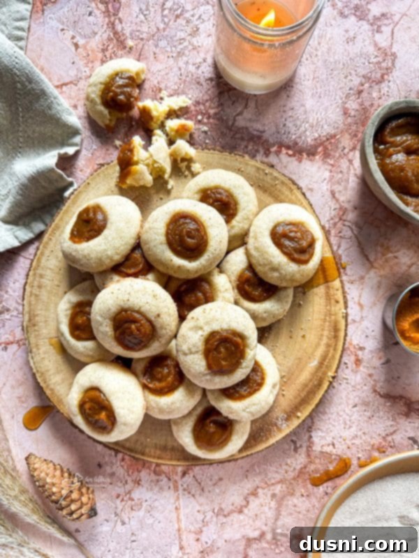 Close-up of golden Snickerdoodle Thumbprint Cookies on a baking sheet, freshly baked.