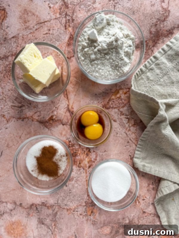A plate of pumpkin butter snickerdoodle thumbprint cookies with a bowl of pumpkin butter in the background.