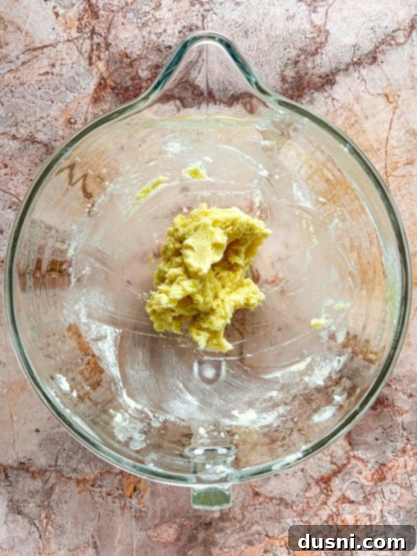 Creaming butter and sugar in a stand mixer bowl for cookie dough.